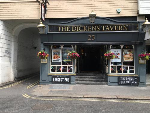 a restaurant with a sign that reads the dickens tavern at St George Hotel in London