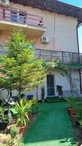 une maison avec une pelouse verte devant dans l'établissement Casa Natalia, à Eforie Nord