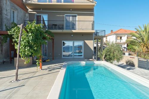a villa with a swimming pool in front of a house at Luxury apartments Lun in Lun