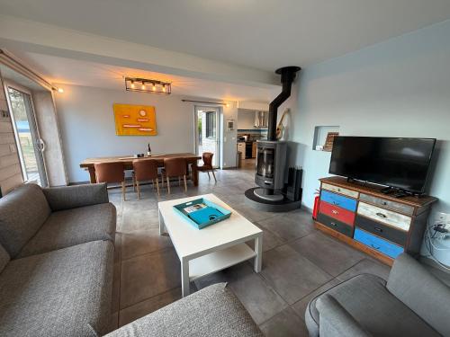 a living room with a couch and a table at Beach House in Port-Bail-sur-Mer