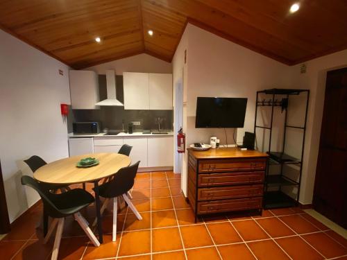 Alqueidão da SerraにあるDa Serra Studio Houseのキッチン(テーブル、椅子、テレビ付)