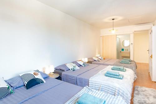 - une chambre avec 2 lits avec des draps bleus dans l'établissement Le Mas de la Clé d'Or - Maison en pierre et piscine, à Puget-sur Argens