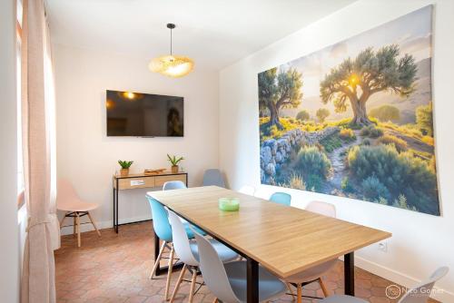 une salle à manger avec une table et un tableau au mur dans l'établissement Le Mas de la Clé d'Or - Maison en pierre et piscine, à Puget-sur Argens