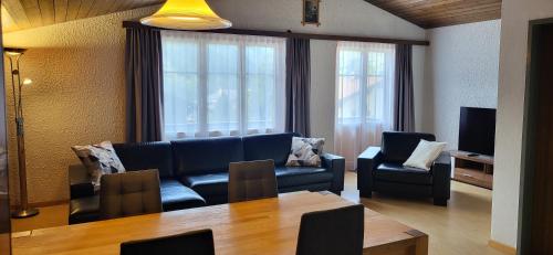a living room with a couch and chairs and a table at Tgèsa Val in Sedrun