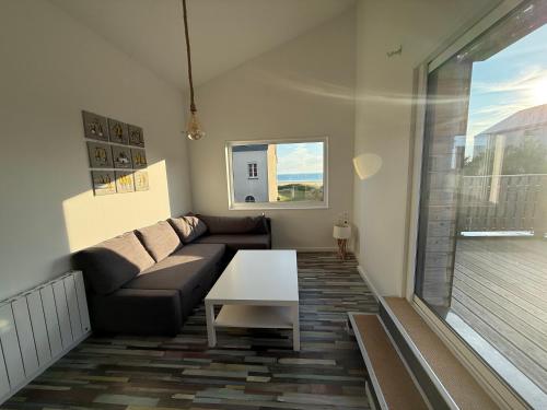 a living room with a couch and a table at Beach House in Port-Bail-sur-Mer