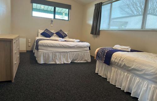 a bedroom with two beds and a window at Otorohanga Kiwi Holiday Park in Otorohanga