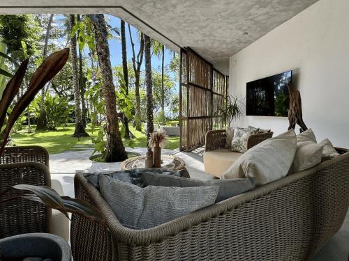 a living room with a couch and a tv at Villa Turquesa - Home in Morro de São Paulo