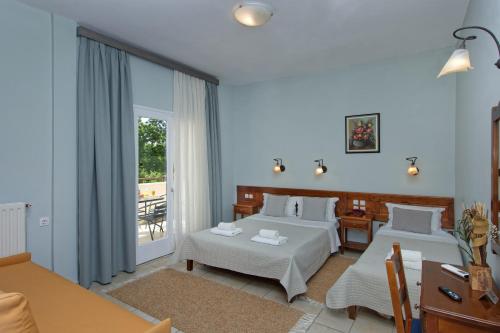 a hotel room with two beds and a balcony at Katia Hotel in Afissos