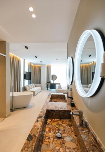 a bathroom with a tub and a large mirror at Green Light Hotel in Ksamil