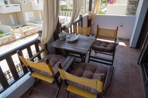 a balcony with a wooden table and chairs at Villa Castello in Iraklitsa