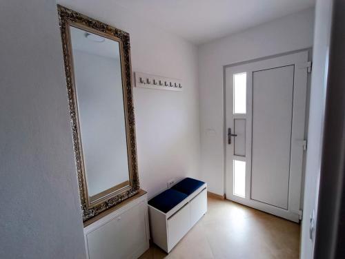 a mirror on a wall next to a room with a bench at Apartma LANA in Koper