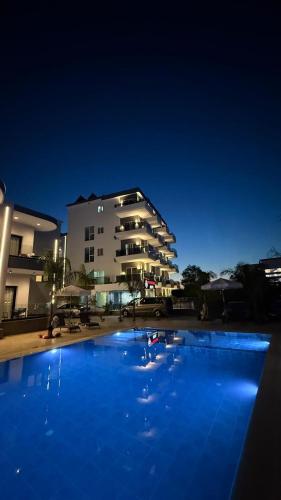 a large blue swimming pool in front of a building at Summer Gate Hotel in Ksamil