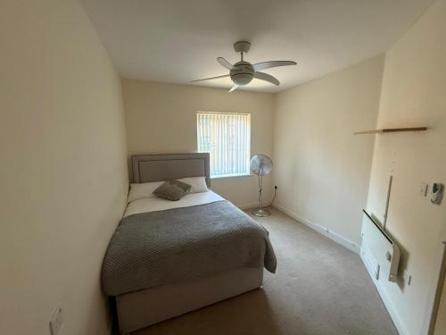 a bedroom with a bed and a ceiling fan at Stylish 1-Bed gated Flat with free Parking and steps from Bournemouth Beach in Bournemouth