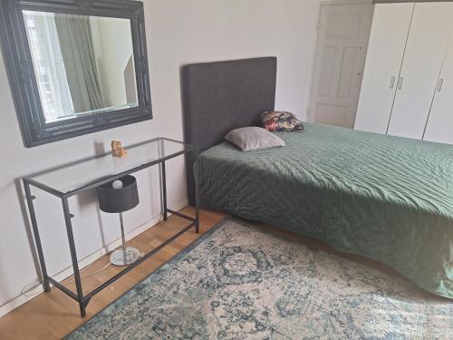 a bedroom with a bed and a mirror and a table at Klockargården Örja byväg 17 in Landskrona