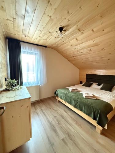 a bedroom with a bed and a wooden ceiling at Cabana Mirajul in Rimetea