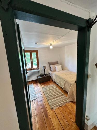 a bedroom with a bed in a room with wooden floors at N2Quartier in Hellenthal