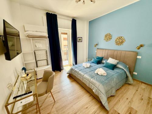 a bedroom with a bed with blue walls and a television at La Zisa Luxury Apartment in Palermo