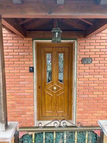 a wooden door on a brick wall with a lamp at La Mermellina, 20 in Arriondas