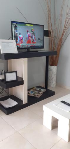 a television on a black stand in a room at Victoria casa temporario in Santo Tomé