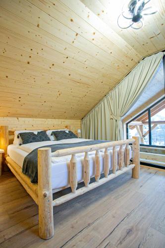 a bed in a room with a wooden ceiling at Chalet pod Strážovom in Zliechov