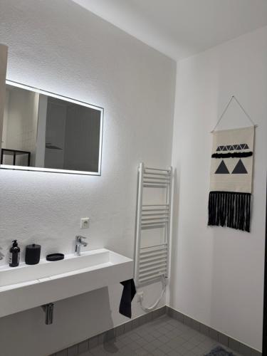 a white bathroom with a sink and a mirror at Boho Loft Apartment am Ziegeltor in Amberg