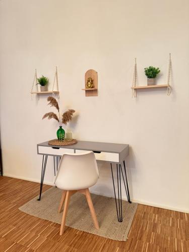 a desk with a chair and a table with a plant at Boho Loft Apartment am Ziegeltor in Amberg