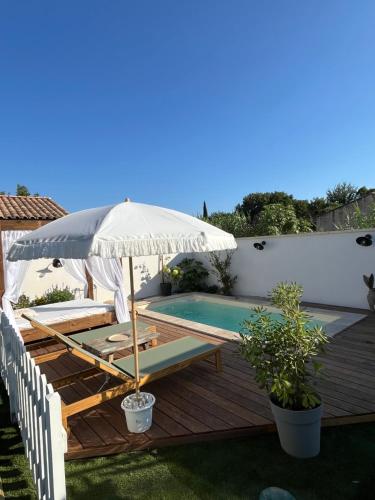 un patio avec un parasol et une piscine dans l'établissement Villa avec piscine privée, à Cadenet