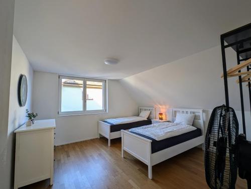 a bedroom with two beds and a window at Swiss Suites - Stusslingen in Lostorf