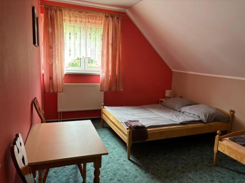a bedroom with a bed and a table and a window at Agroturystyka Radzewicz in Wiżajny