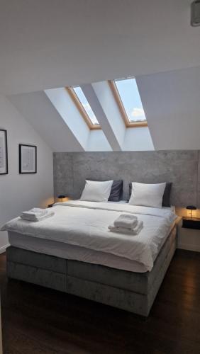 a bedroom with a large bed with skylights at Palace apartments 23 in Sremska Mitrovica
