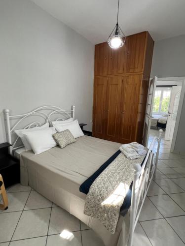 a bedroom with a bed and a wooden cabinet at JET, luxury appartment 20m from the beach in Kinion