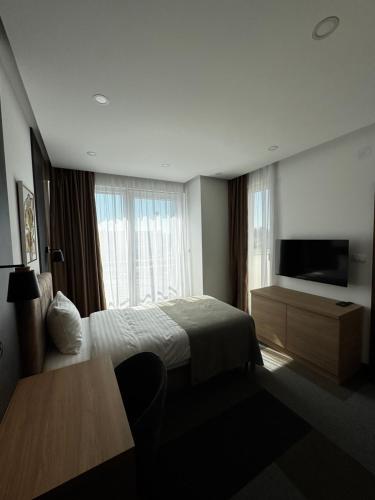 a hotel room with a bed and a flat screen tv at Aura in Loznica