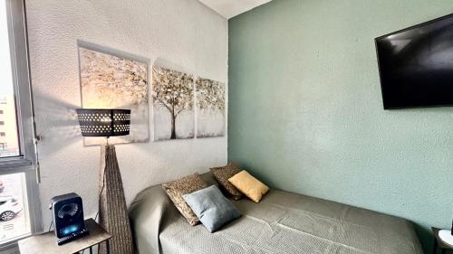 une pièce avec un canapé avec une lampe et une télévision dans l'établissement Studio Oiseau Bleu Plage Môle Port & Centre Cap d Agde, au Cap d'Agde