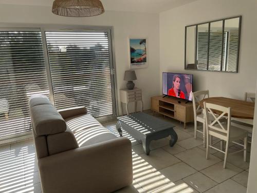 un salon avec un canapé et une table dans l'établissement Location appartement au lavandou, au Lavandou