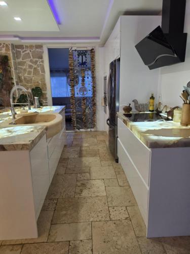 une cuisine avec des armoires blanches et un sol carrelé dans l'établissement Beautiful sea view, quiet in agricultural property, à Antibes