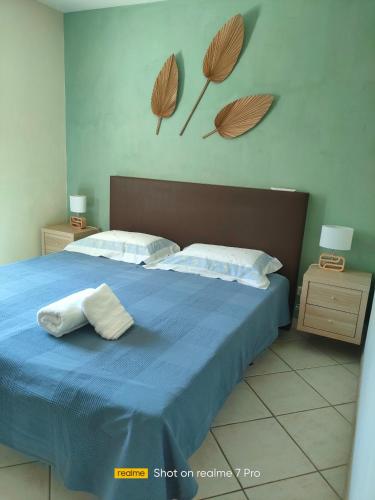 une chambre avec un lit bleu avec deux oreillers dessus dans l'établissement Villa au pied d'une colline, à La Farlède