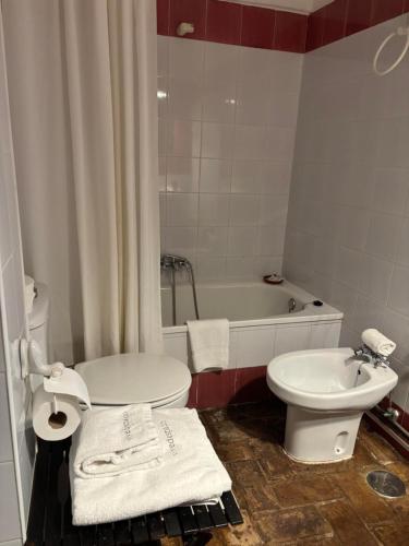 a bathroom with a toilet and a sink and a tub at Hospedería Convento de la Parra, 06176 in La Parra