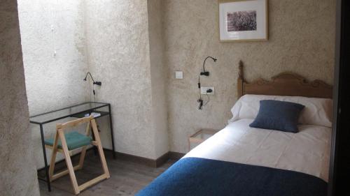 San Miguel de ValeroにあるSueñoRuralのベッドルーム1室(ベッド1台、テーブル、椅子付)