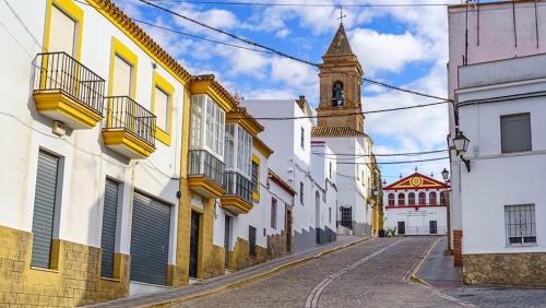 an empty street in a town with a clock tower at La casa de loto in Alcalá de los Gazules