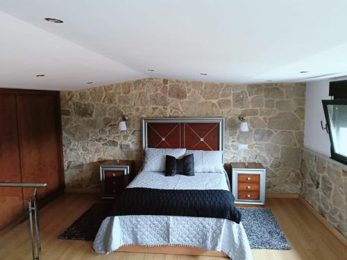 una camera da letto con un letto e un muro di pietra di Casa Consuelo a Sabardes