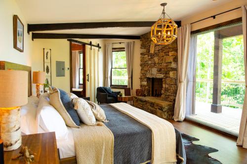 a bedroom with a large bed and a fireplace at Elk & Embers Mountain Hideaway in Waynesville