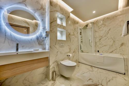a bathroom with a toilet and a sink and a mirror at Aura in Loznica