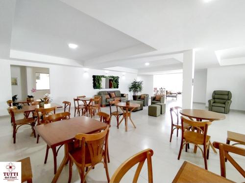 un comedor con mesas y sillas y un sofá en Pousada Tutti Del Fiori, en Maracás