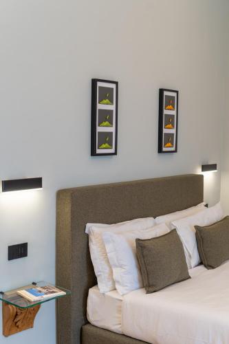 a bedroom with a bed and some pictures on the wall at Deluxe Spaccanapoli in Naples