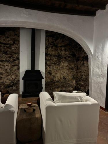a living room with a couch and a fireplace at Hospedería Convento de la Parra, 06176 in La Parra