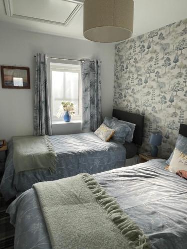 a bedroom with two twin beds and a window at Sea view cottage in Allonby