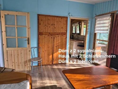 a room with a door and a table and a chair at Ośrodek Wypoczynkowy Feniks in Pogorzelica
