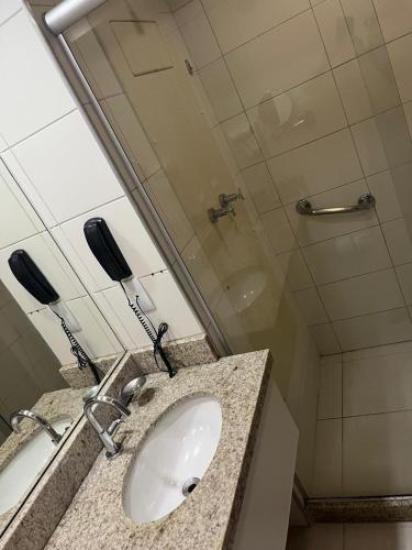 a bathroom with a sink and a mirror at Beira Mar - Flat Beach Class Internacional - Boa Viagem 20º andar in Recife