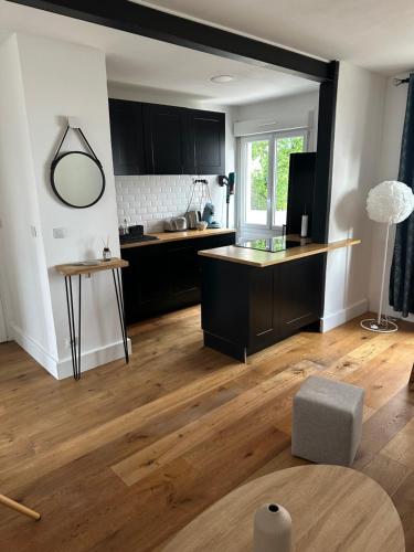 a kitchen with black cabinets and a wooden floor at Joli appartement à Talence in Talence
