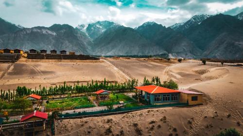 an aerial view of a farm with mountains in the background at Green Land Resort, Katpanah Lake, Skardu, Gilgit Baltistan in Skardu